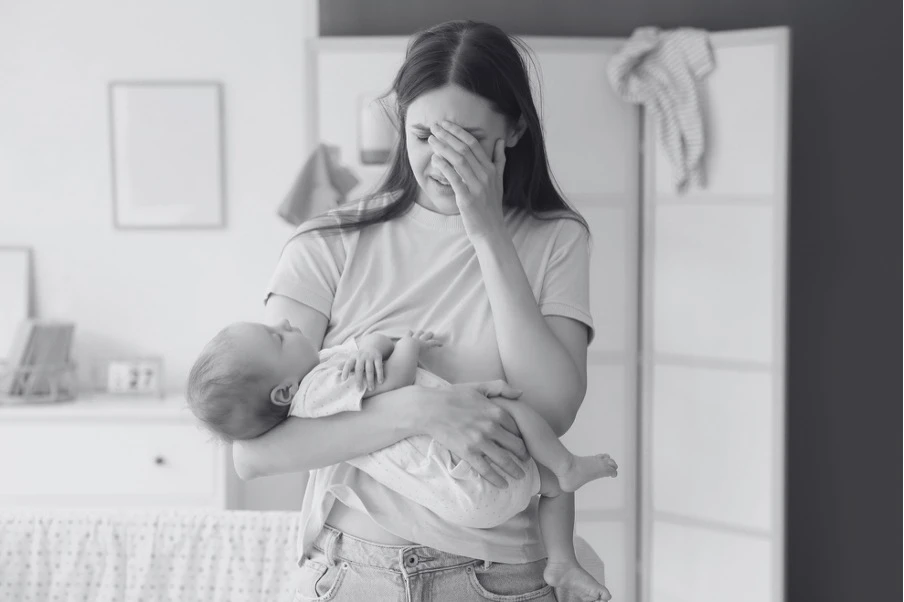 Mère tenant son bébé dans un moment de vulnérabilité et de soutien post-partum