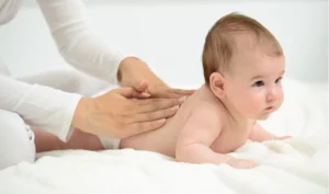 Parent massant doucement son bébé lors d’un atelier massage bébé d’accompagnement émotionnel